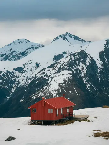 Red cabin in snowy mountains